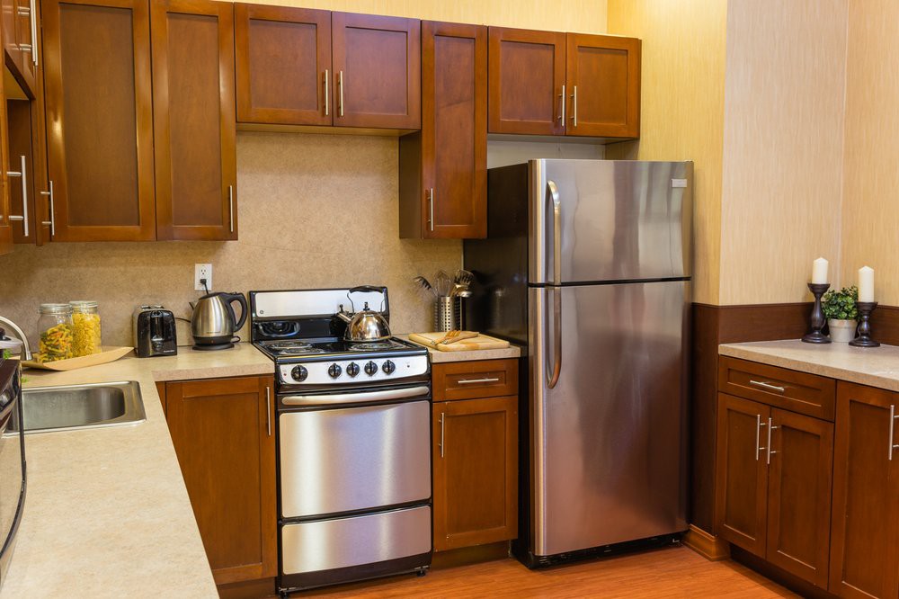 Modern kitchen with stainless steel appliances and wooden cabinets.