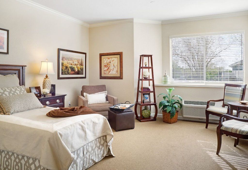 A cozy bedroom with a comfortable armchair, stylish decor, and natural light streaming through the window.