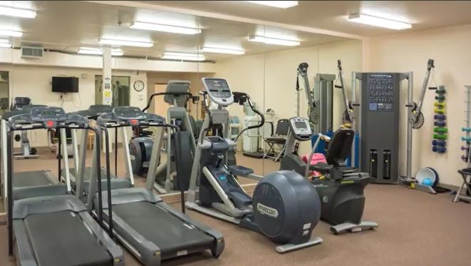A well-equipped gym with various fitness machines and weights.