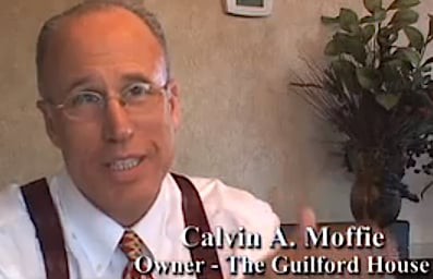 A man wearing glasses and a suit speaking, with text indicating he is an owner.