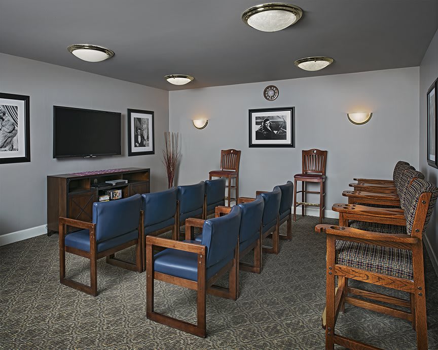 A small meeting room with rows of chairs facing a television.