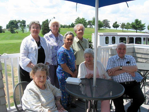A joyful gathering of seniors enjoying a sunny day outdoors.