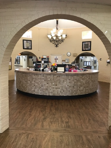 A welcoming reception area with a modern curved front desk and elegant chandelier.