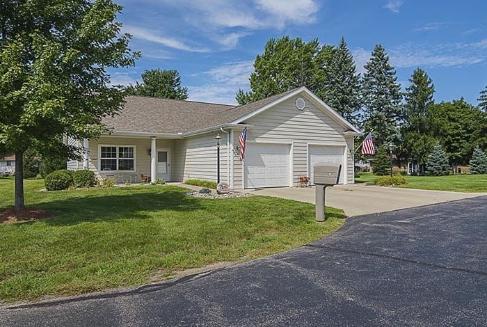A suburban residential house with a well-maintained lawn and driveway.