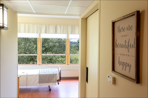 A serene view of a hospital patient room with natural light coming through the windows.