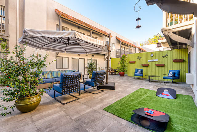 A cozy outdoor patio area with comfortable seating and an umbrella, perfect for relaxation.
