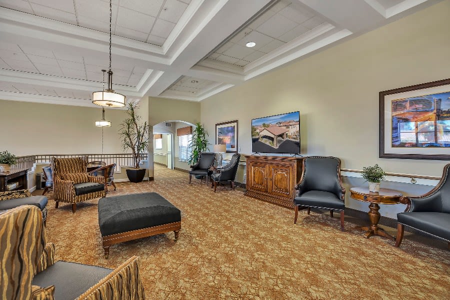 A cozy and elegantly decorated lobby with comfortable seating, artwork on the walls, and ambient lighting.