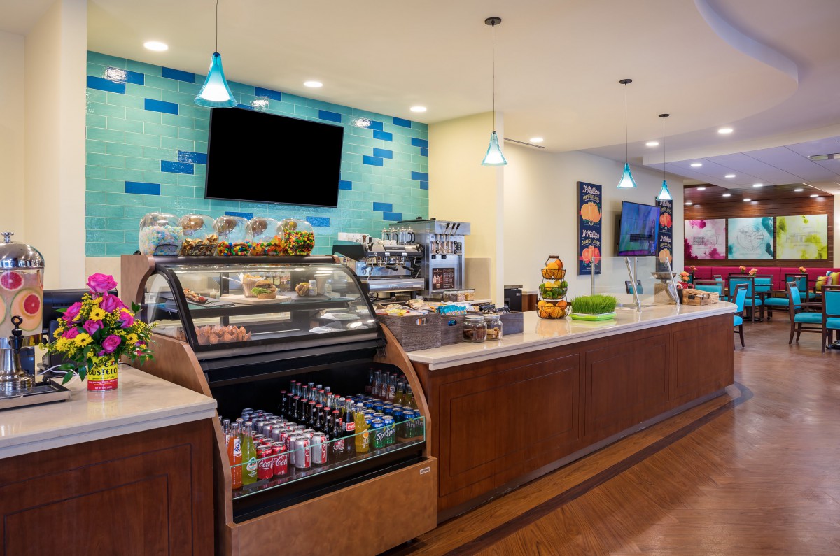 Modern cafe interior with a display case of pastries and drinks.
