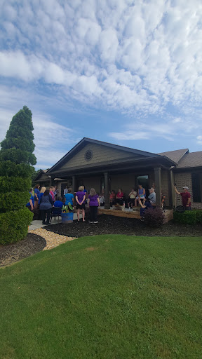 A community gathering outside a house on a sunny day.