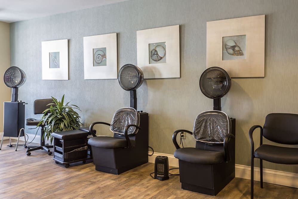 A salon interior featuring hair drying chairs and modern decor.