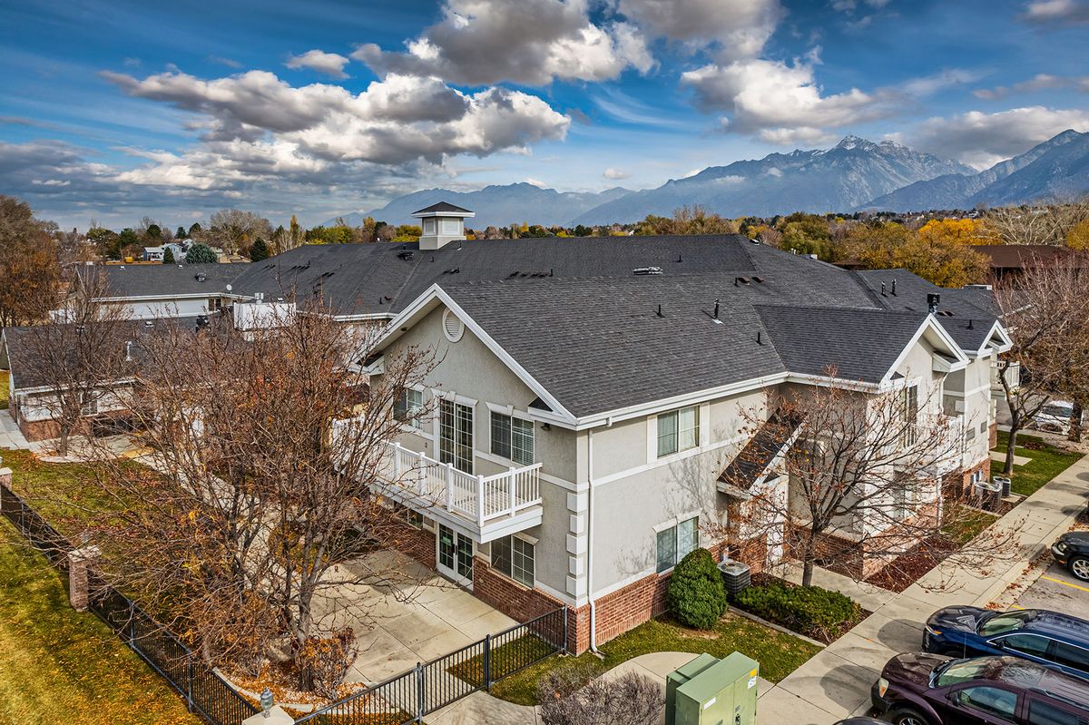 A suburban house with a scenic mountain backdrop and partly cloudy skies.