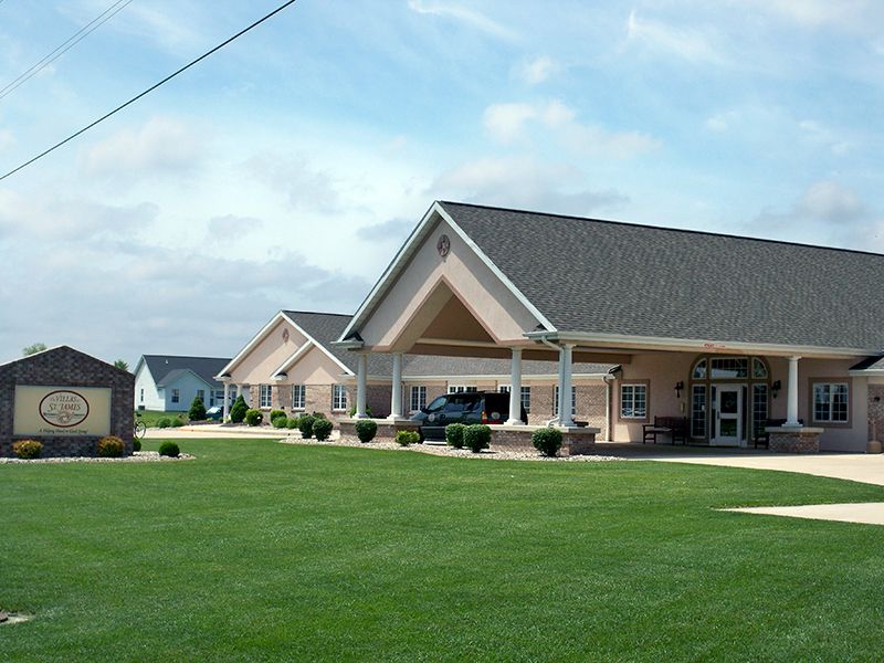 A suburban building with a large lawn and clear sky.
