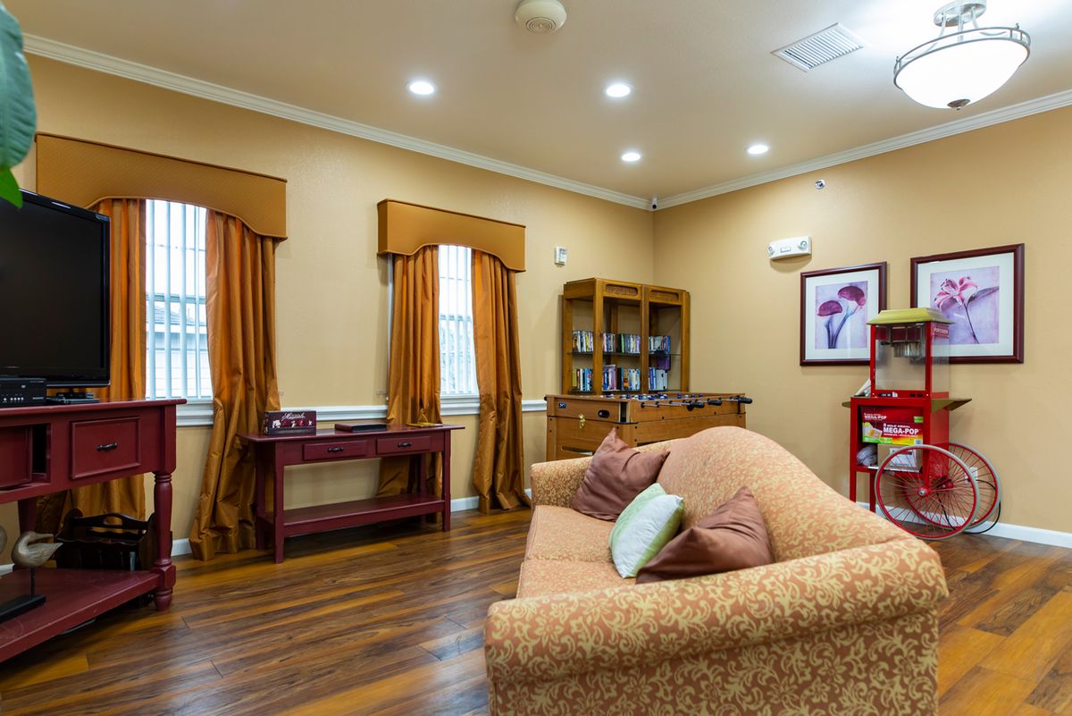 A cozy living room with warm tones, featuring a couch, wooden floors, and elegant decor.