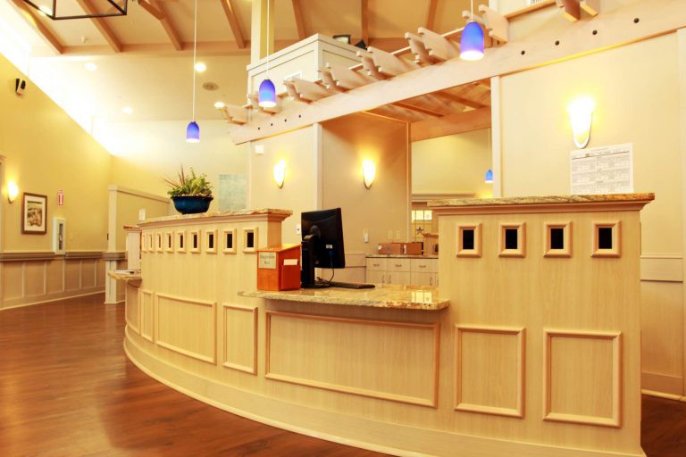 A modern reception desk area with warm lighting and a computer setup.
