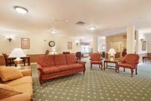 A comfortable living room with sofas, chairs, and a patterned carpet.