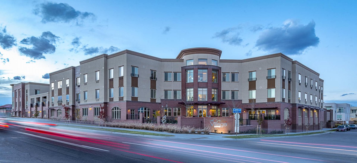 A modern building with a contemporary architectural design illuminated at dusk.