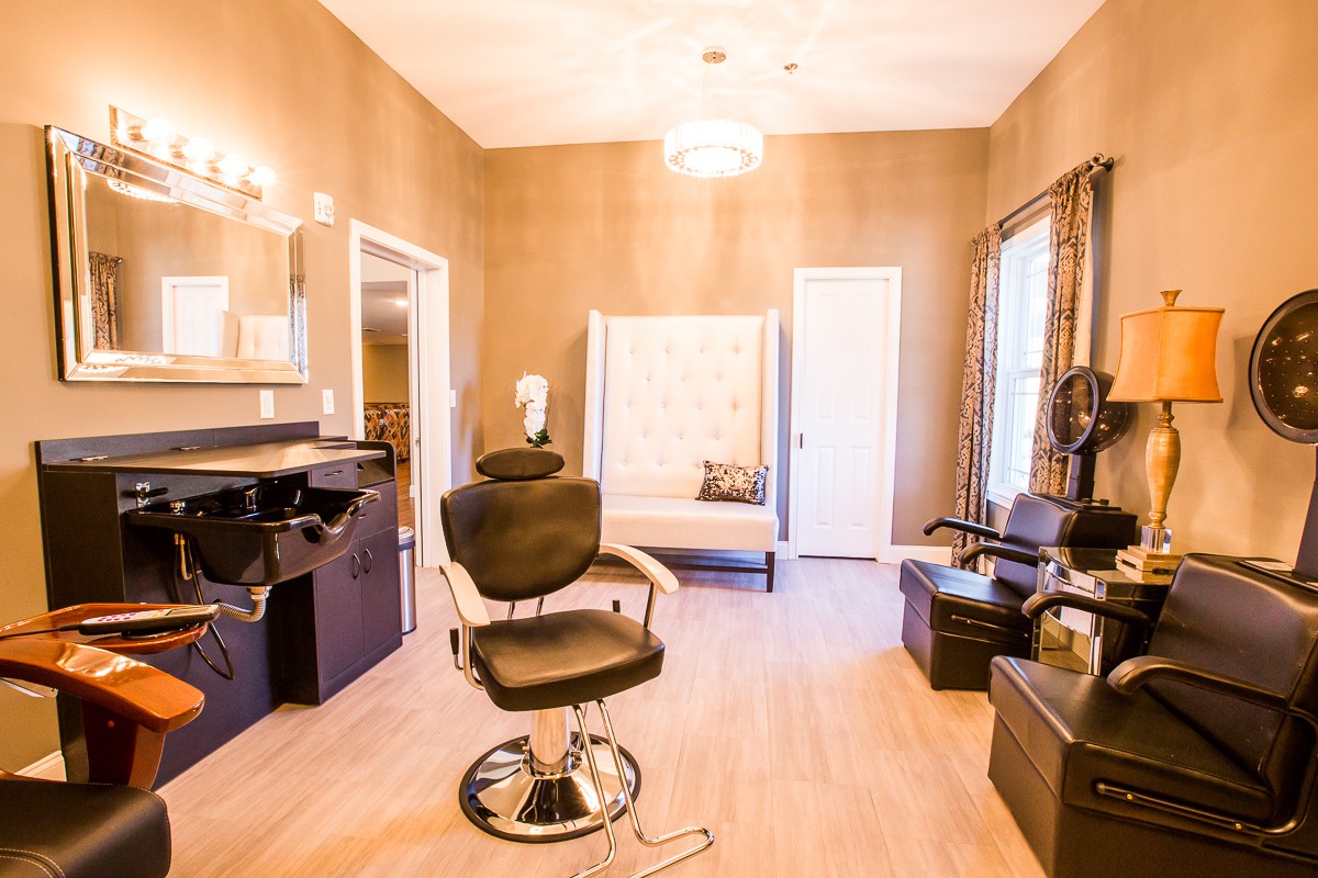 A well-lit beauty salon interior featuring chairs and mirrors.