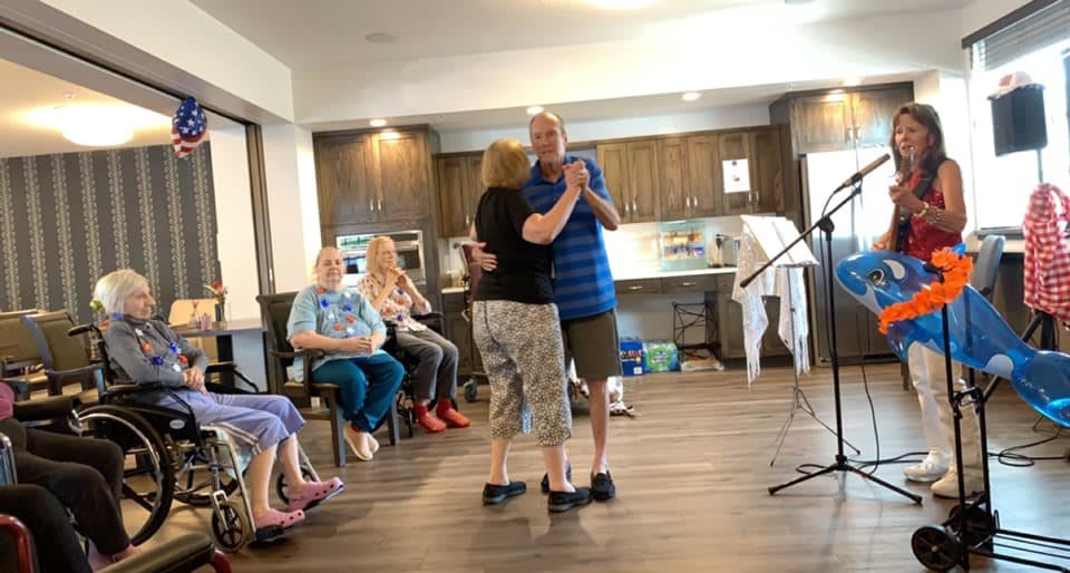 A couple dances together in front of an audience at a senior center.