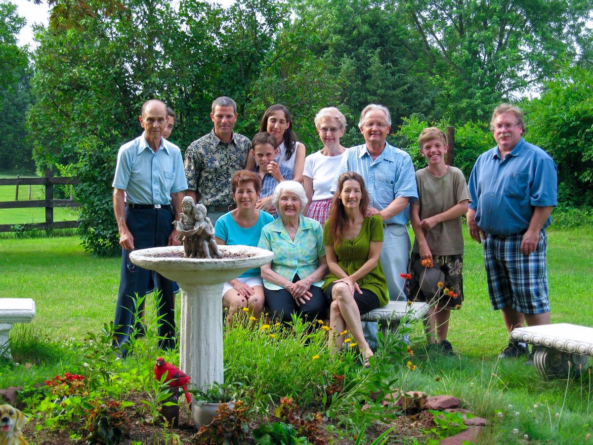 A family posing together in a garden setting on a summer day.