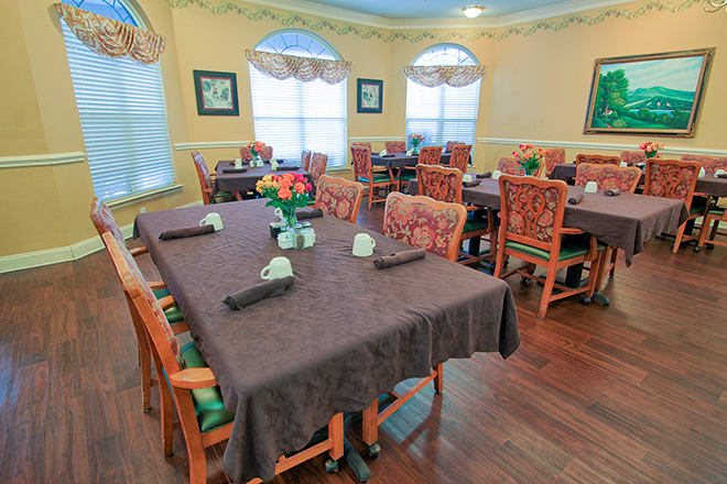 A cozy dining room with neatly arranged tables and chairs, featuring elegant decor.