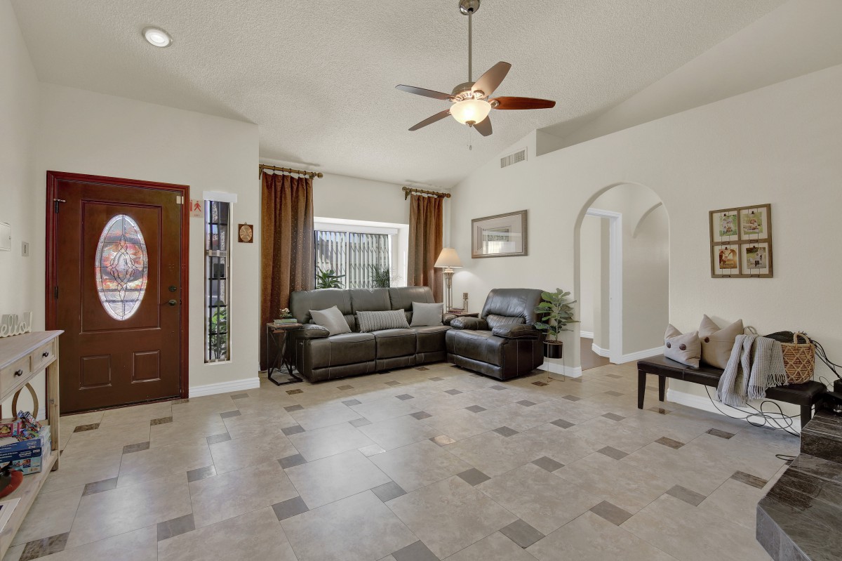 A spacious living room with modern furniture and tiled flooring.