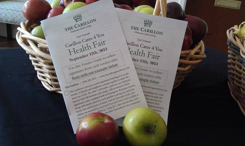 Flyers advertising a Health Fair are displayed in front of a basket filled with apples.