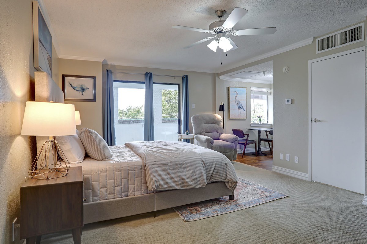 A modern and cozy bedroom interior with elegant furniture and large windows.