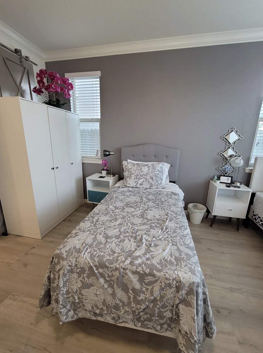 A cozy bedroom with a single bed, wardrobe, and decorative elements.