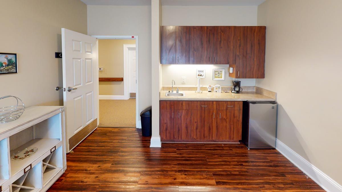 A modern kitchen with wooden flooring and compact design.