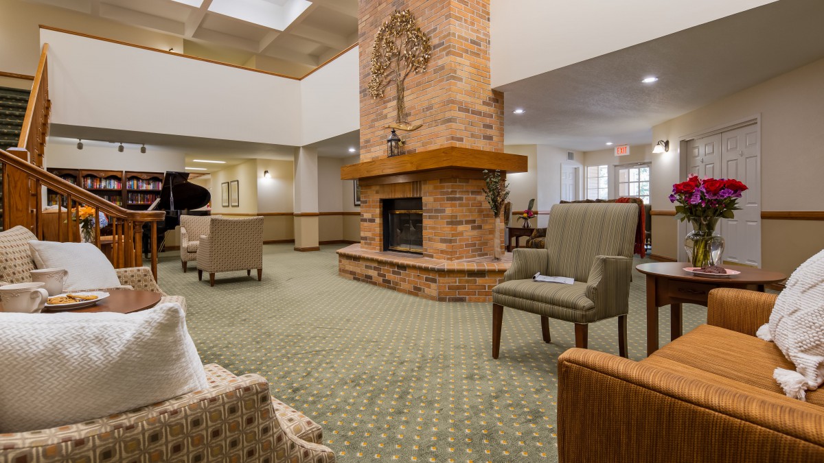 A cozy lounge area with a central brick fireplace and comfortable seating.