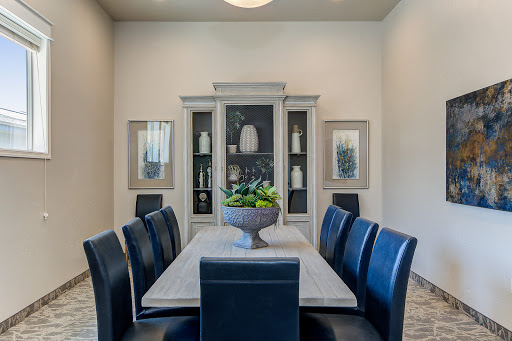 A stylish dining room featuring a modern table, dark chairs, and elegant decor.