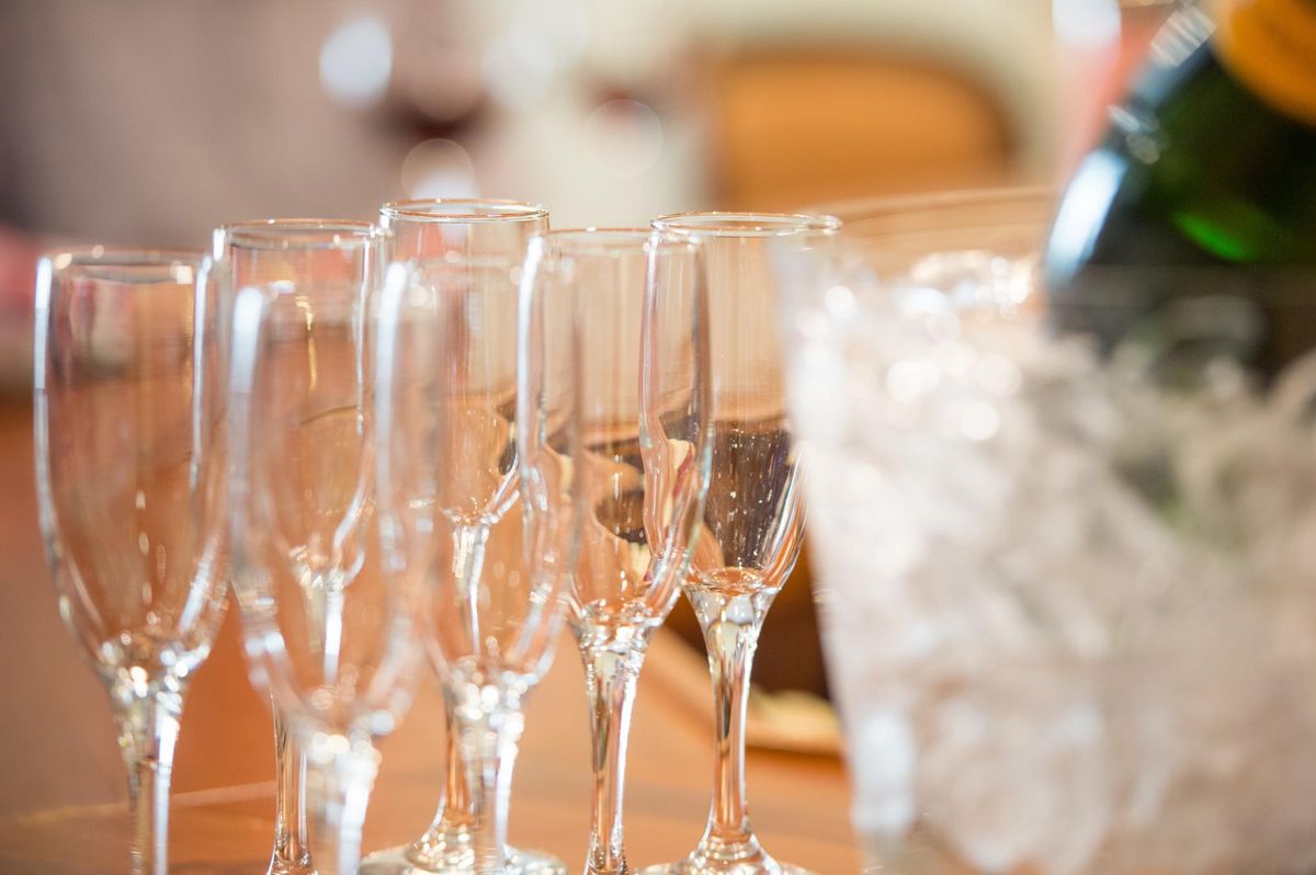 A row of empty champagne glasses alongside an ice bucket, ready for a celebration.