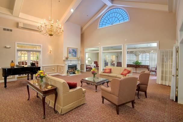A cozy and elegant living room with comfortable seating, a fireplace, and a chandelier.