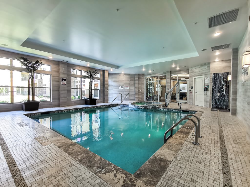 A modern indoor swimming pool with sleek design and ambient lighting.