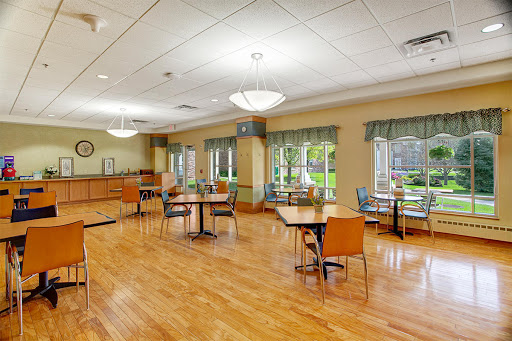 A spacious dining area featuring wooden flooring and ample natural light, designed for comfort and social interaction.