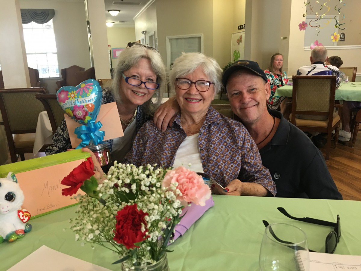 A joyful family gathering with smiles and flowers.
