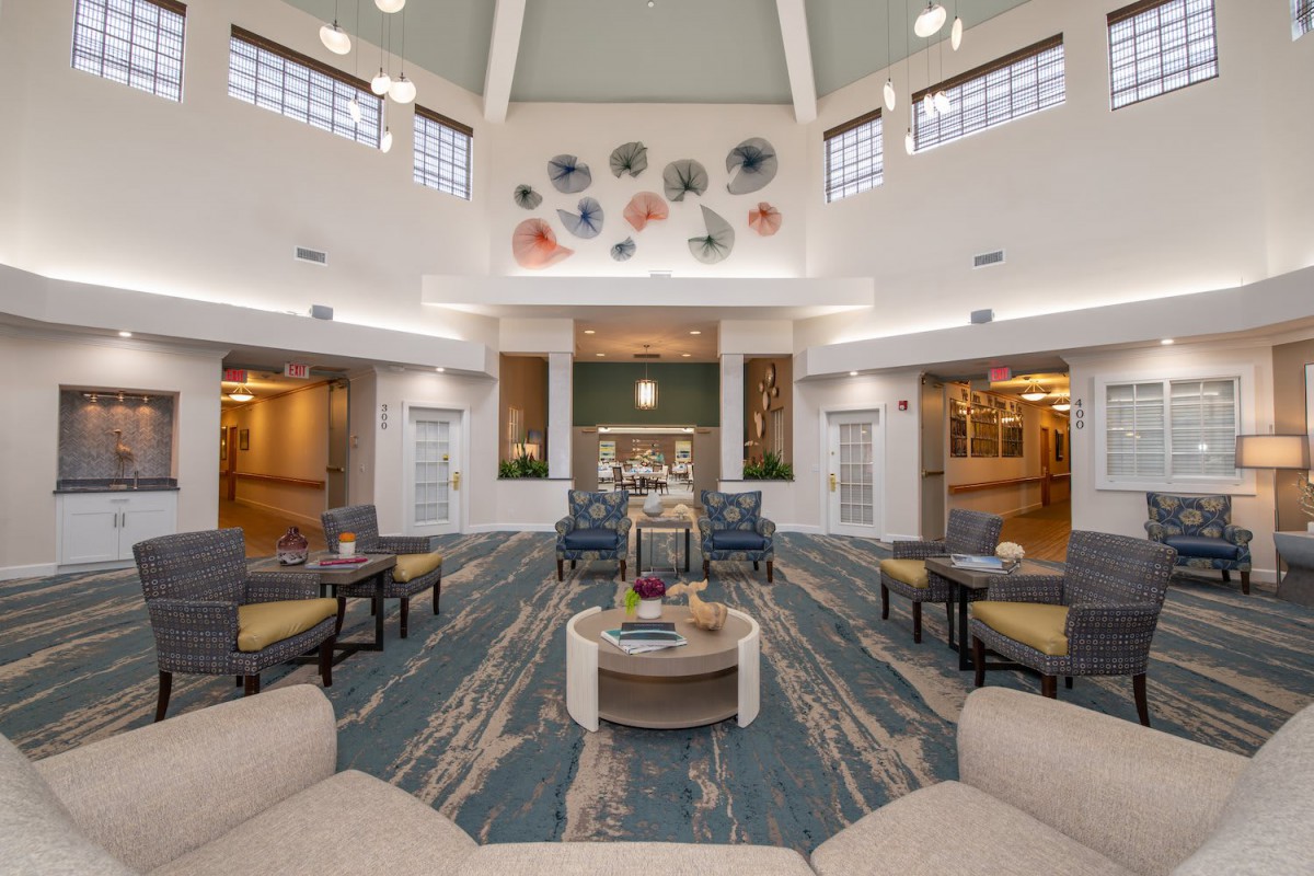 A spacious and well-lit lounge area with comfortable seating and decorative elements on the walls.