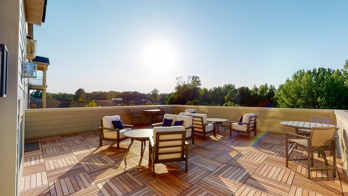 A sunny outdoor patio with comfortable seating and tables.
