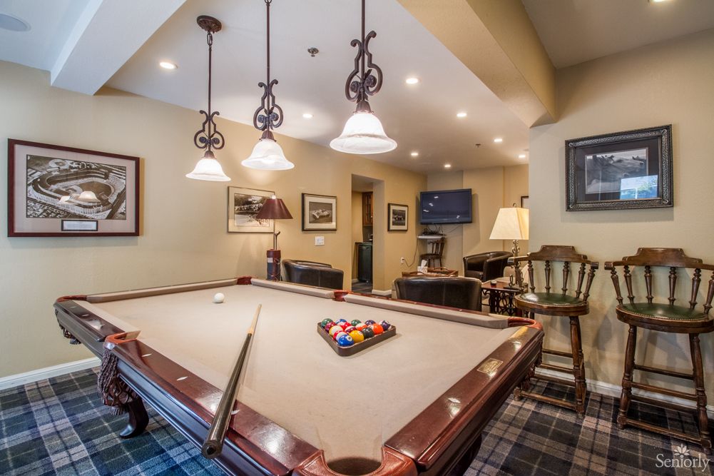 A cozy billiard room with a pool table and elegant lighting.