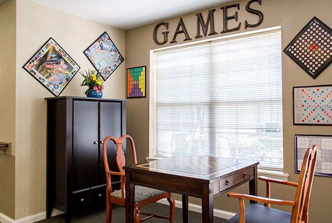 A cozy games room with a table, chairs, and decorative elements.