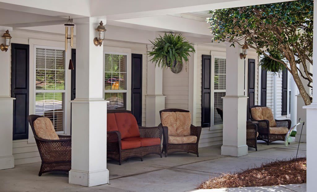 A cozy porch with comfortable seating and a hanging plant.