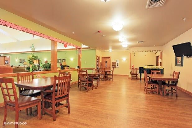 An empty restaurant dining area with wooden tables and chairs.