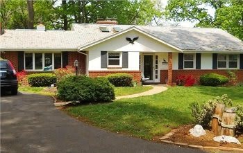 A suburban house with a well-maintained lawn and driveway.