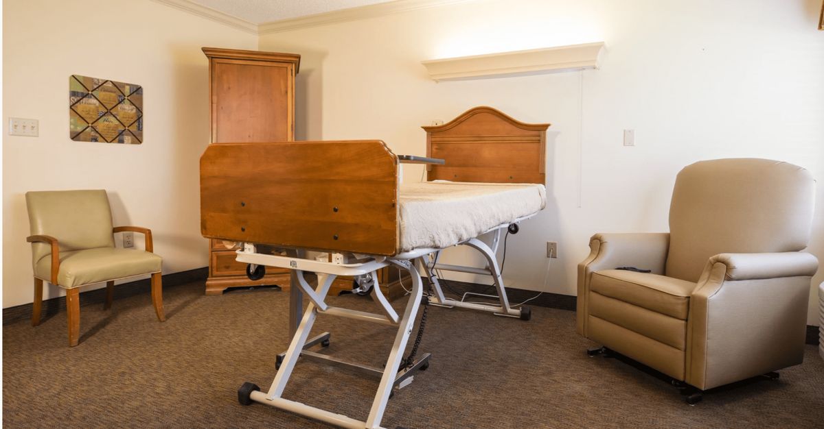 Hospital bed in a patient room with wooden furnishings.
