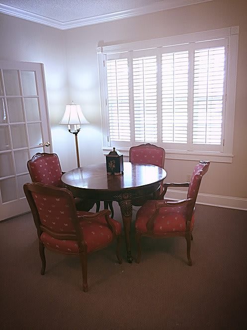 A cozy dining area with a round wooden table and four upholstered chairs.
