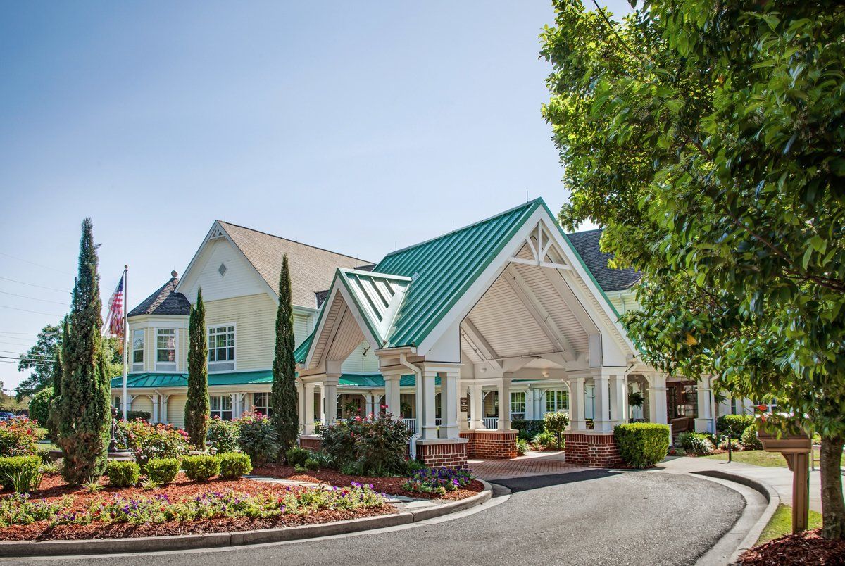 A charming hotel entrance with a green roof and well-maintained landscaping.
