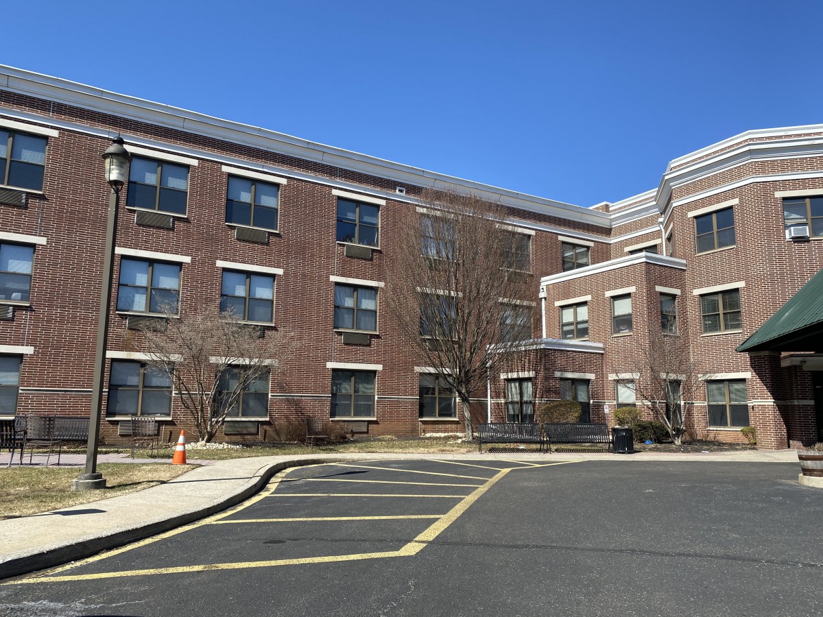 A brick school building with multiple windows under a clear blue sky.