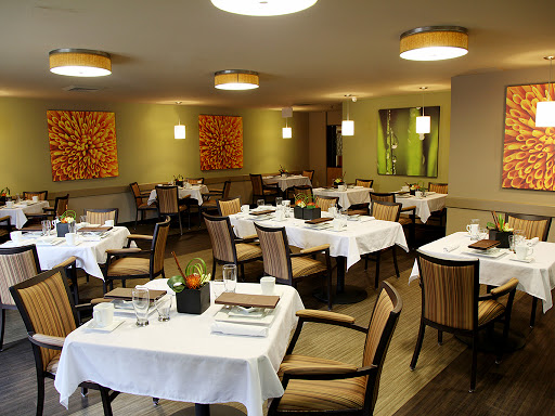 A stylish and modern dining area featuring neatly arranged tables and comfortable chairs.