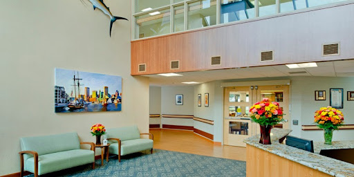 A welcoming hospital lobby featuring comfortable seating, colorful flower arrangements, and modern artwork.