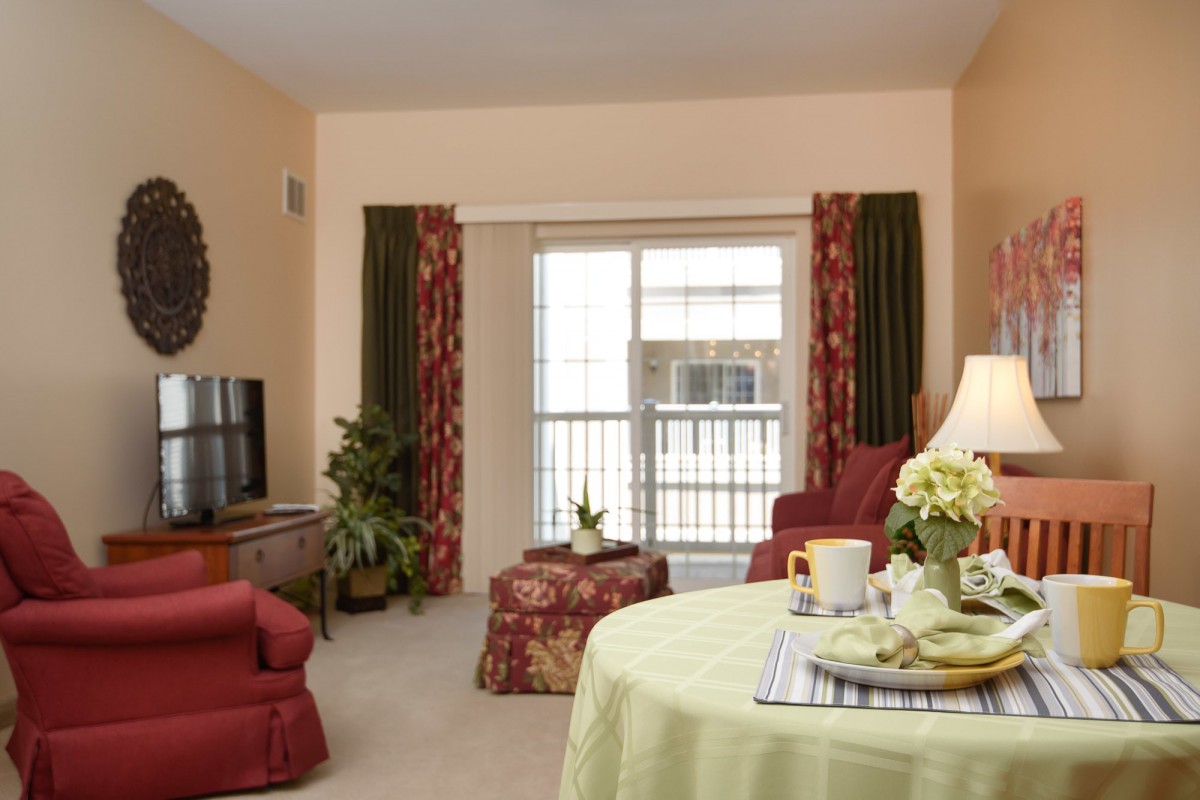 A cozy living room with warm colors, featuring a sofa, television, and decorative accents.